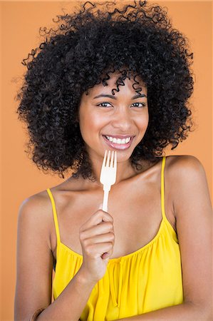 simsearch:6108-06906446,k - Portrait of a woman holding a fork and smiling Photographie de stock - Premium Libres de Droits, Code: 6108-06904753