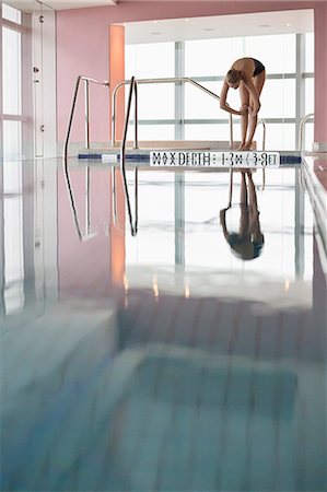 Woman diving into a swimming pool Photographie de stock - Premium Libres de Droits, Code: 6108-06904725