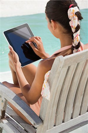 Woman sitting on a chair and using digital tablet on the beach Foto de stock - Sin royalties Premium, Código: 6108-06904852