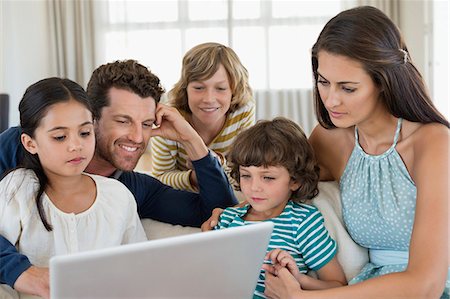 Family looking at a laptop Stock Photo - Premium Royalty-Free, Code: 6108-06904863