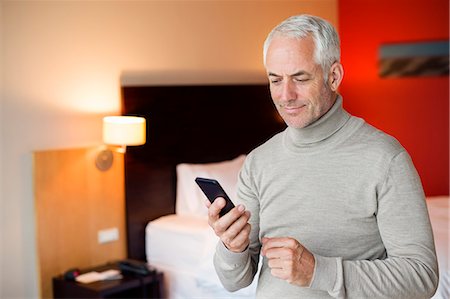 simsearch:6108-06907854,k - Man using a cell phone in a hotel room Stock Photo - Premium Royalty-Free, Code: 6108-06904880