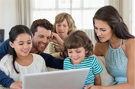 dad kid computer - Family looking at a laptop Stock Photo - Premium Royalty-Free, Code: 6108-06904829