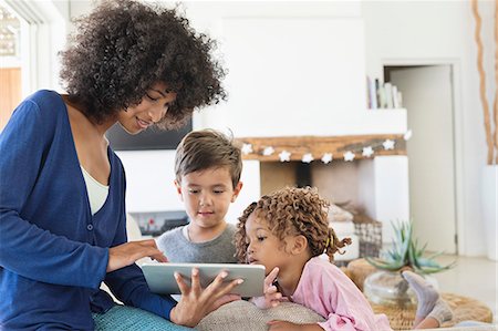 Woman showing a digital tablet to her children Stock Photo - Premium Royalty-Free, Code: 6108-06904839