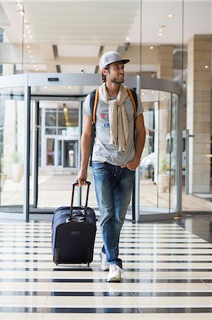 shoestring traveller - Man pulling his luggage at an airport Stock Photo - Premium Royalty-Free, Code: 6108-06904953