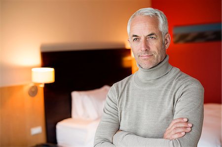 simsearch:6108-06907173,k - Man with arms crossed in a hotel room Photographie de stock - Premium Libres de Droits, Code: 6108-06904970