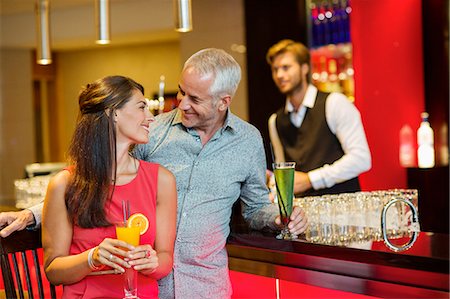 Couple enjoying drinks at the bar counter Stock Photo - Premium Royalty-Free, Code: 6108-06904982