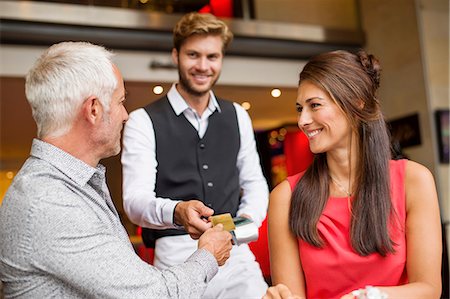 Couple paying with a credit card to a waiter in a restaurant Foto de stock - Sin royalties Premium, Código: 6108-06904992