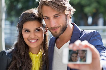 Couple taking picture of themselves with a mobile phone Foto de stock - Sin royalties Premium, Código: 6108-06904920