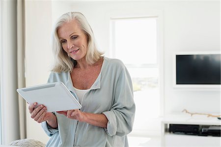 Woman using a digital tablet Stock Photo - Premium Royalty-Free, Code: 6108-06905092