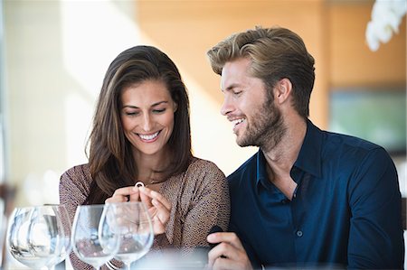 Man giving engagement ring to his girlfriend in a restaurant Stock Photo - Premium Royalty-Free, Code: 6108-06905156