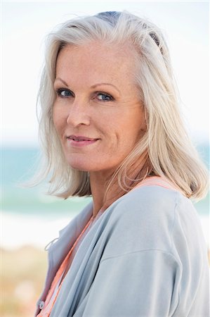senior woman closeup - Portrait of a woman smiling on the beach Photographie de stock - Premium Libres de Droits, Code: 6108-06905117