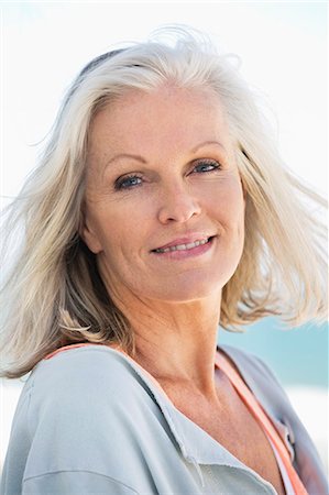 senior woman closeup - Portrait of a woman smiling on the beach Stock Photo - Premium Royalty-Free, Code: 6108-06905114