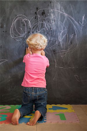 Rear view of a girl writing on a blackboard Foto de stock - Sin royalties Premium, Código: 6108-06905284