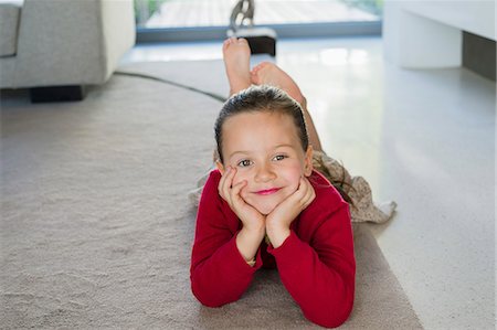 Girl lying on a carpet at home Stock Photo - Premium Royalty-Free, Code: 6108-06905295