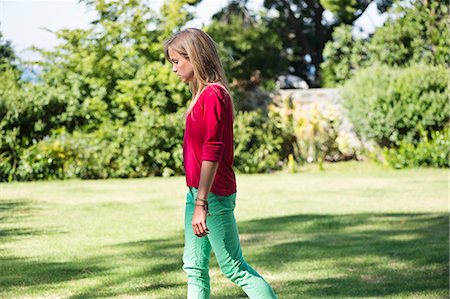 Girl walking on the grass in a lawn Stock Photo - Premium Royalty-Free, Code: 6108-06905218