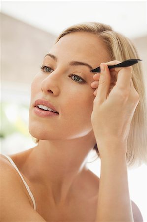 Woman tweezing her eyebrows Foto de stock - Sin royalties Premium, Código: 6108-06905375