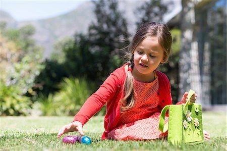 simsearch:6108-05870485,k - Girl picking up Easter eggs in a lawn Foto de stock - Royalty Free Premium, Número: 6108-06905337