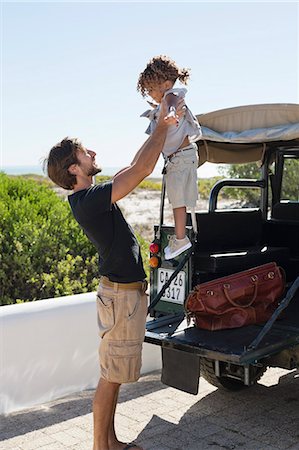 family bag - Man playing with his daughter beside a SUV Stock Photo - Premium Royalty-Free, Code: 6108-06905573
