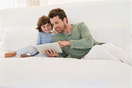 Man showing a digital tablet to his son Photographie de stock - Premium Libres de Droits, Code: 6108-06905587