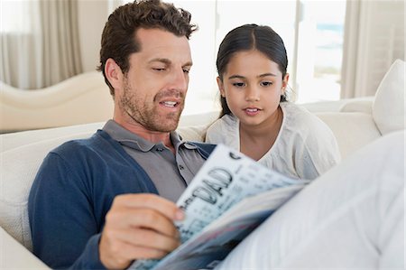 Man and his daughter reading a magazine Photographie de stock - Premium Libres de Droits, Code: 6108-06905588