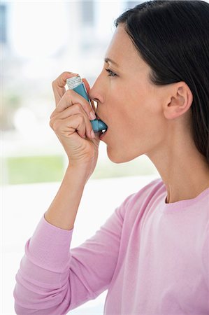 Close-up of a woman using an asthma inhaler Stock Photo - Premium Royalty-Free, Code: 6108-06905643