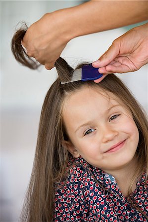 poux - Close-up of a woman's hand combing her daughter's hair Photographie de stock - Premium Libres de Droits, Code: 6108-06905641