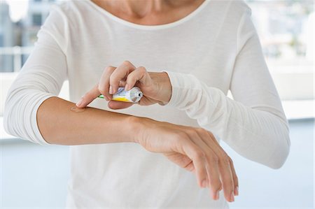 Woman applying ointment on her arm Photographie de stock - Premium Libres de Droits, Code: 6108-06905671