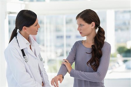 doctor with female patient stethoscope - Patient discussing with a doctor Stock Photo - Premium Royalty-Free, Code: 6108-06905686