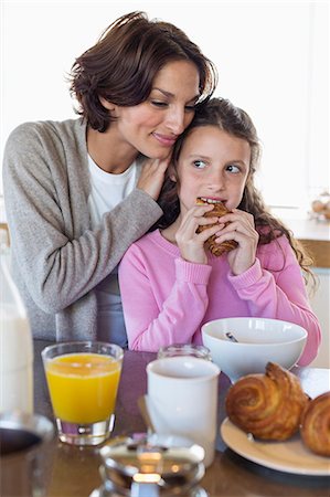 drink milk of woman - Girl having breakfast beside her mother at a kitchen counter Stock Photo - Premium Royalty-Free, Code: 6108-06905600