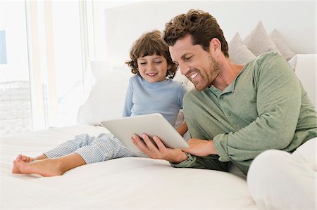 screen time - Man showing a digital tablet to his son Photographie de stock - Premium Libres de Droits, Code: 6108-06905613