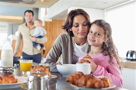 simsearch:614-03818632,k - Girl having breakfast beside her mother at a kitchen counter Stock Photo - Premium Royalty-Free, Code: 6108-06905758