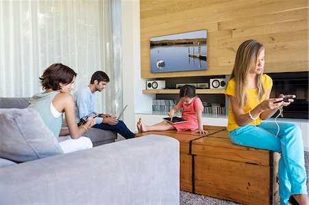 remote control tv - Family using electronics gadgets Stock Photo - Premium Royalty-Free, Code: 6108-06905760