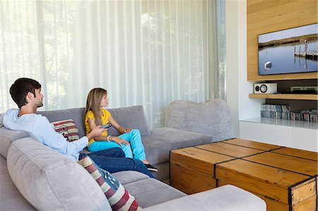 Father watching television with his daughter Foto de stock - Sin royalties Premium, Código: 6108-06905733