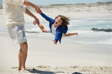 swinging - Man playing with his grandson on the beach Stock Photo - Premium Royalty-Free, Code: 6108-06905946