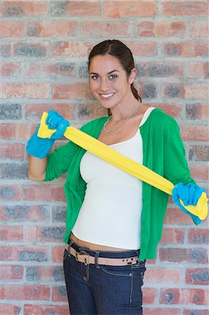 people stand in front brick wall - Portrait of a woman stretching a towel and smiling Foto de stock - Sin royalties Premium, Código: 6108-06905967