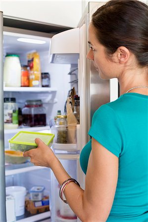 Woman putting food in a refrigerator Stock Photo - Premium Royalty-Free, Code: 6108-06905998