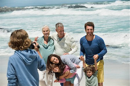 family grandmother grandfather caucasian - Boy filming his family with a home video camera on the beach Stock Photo - Premium Royalty-Free, Code: 6108-06905918