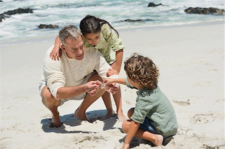 simsearch:6108-06905894,k - Children with their grandfather on the beach Stock Photo - Premium Royalty-Free, Code: 6108-06905919