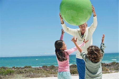 summer time sky - Man playing with his grandchildren on the beach Stock Photo - Premium Royalty-Free, Code: 6108-06905929