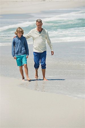 Man walking with his grandson on the beach Foto de stock - Royalty Free Premium, Número: 6108-06905937