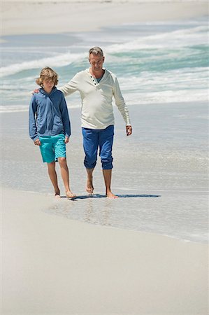 Man walking with his grandson on the beach Stock Photo - Premium Royalty-Free, Code: 6108-06905937