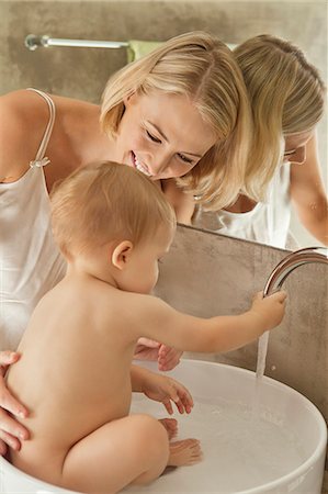 female and bathtub and caucasian - Woman giving bath to her baby in a wash bowl Stock Photo - Premium Royalty-Free, Code: 6108-06906042