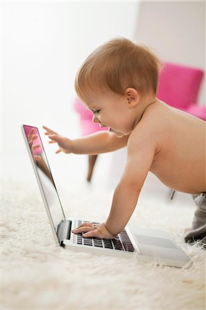 Baby boy playing with a laptop Stock Photo - Premium Royalty-Free, Code: 6108-06906046