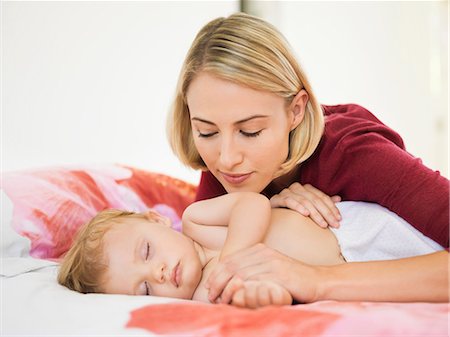 parent baby sleeping - Woman looking at her baby sleeping on the bed Stock Photo - Premium Royalty-Free, Code: 6108-06906086