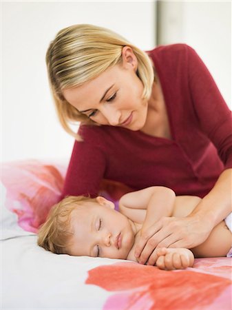 Woman looking at her baby sleeping on the bed Stock Photo - Premium Royalty-Free, Code: 6108-06906091