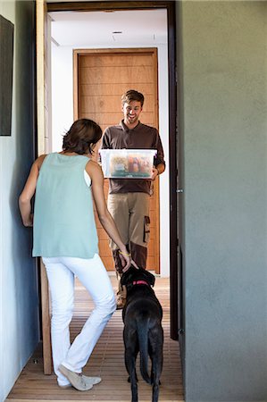 dog doorway - Delivery man delivering parcel to a woman Stock Photo - Premium Royalty-Free, Code: 6108-06906000