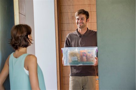 Delivery man delivering parcel to a woman Photographie de stock - Premium Libres de Droits, Code: 6108-06906024