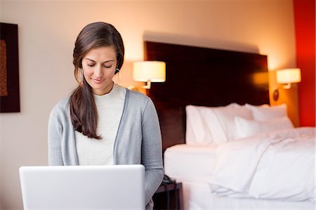 Woman using a laptop in a hotel room Foto de stock - Sin royalties Premium, Código: 6108-06906155