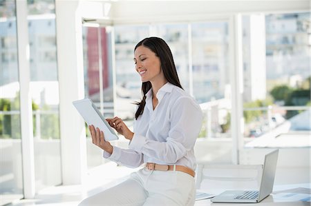 Businesswoman holding a digital tablet and smiling in an office Photographie de stock - Premium Libres de Droits, Code: 6108-06906166