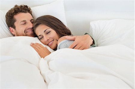 snuggle - Smiling couple lying on the bed Stock Photo - Premium Royalty-Free, Code: 6108-06906198